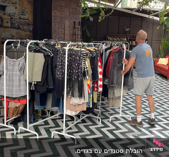 אדם מזיז מתלה בגדים על גלגלים